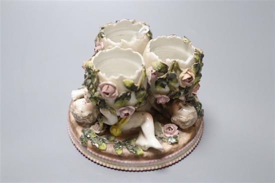 A Sitzendorf trio of vases, supported by floral encrusted putti, diameter 13cm